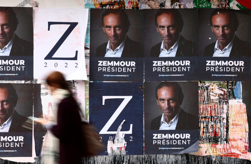  A woman walks past posters in support of French far-right commentator Eric Zemmour, probable candidate for the French presidential election next April, posted on a wall in Paris, France, October 13, 2021. (photo credit: REUTERS/SARAH MEYSSONNIER)