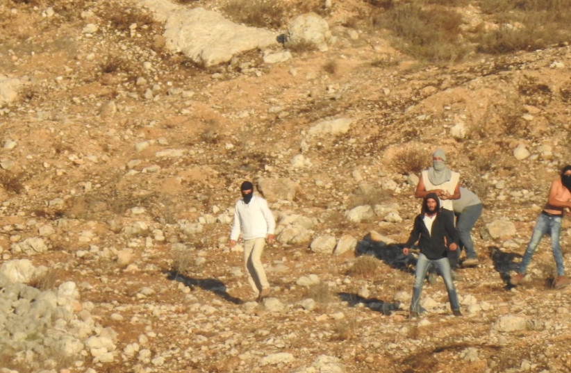  Israeli settlers are seen on the edge Burin village in the West Bank in early November. (photo credit: YESH DIN)