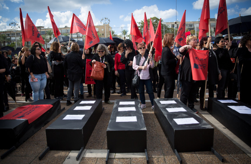  Israeli women hold fake coffins symbolizing the murders of women killed in domestic violence as part of a nationwide strike  protesting the violence against women, December 2018 (credit: MIRIAM ALSTER/FLASH90)