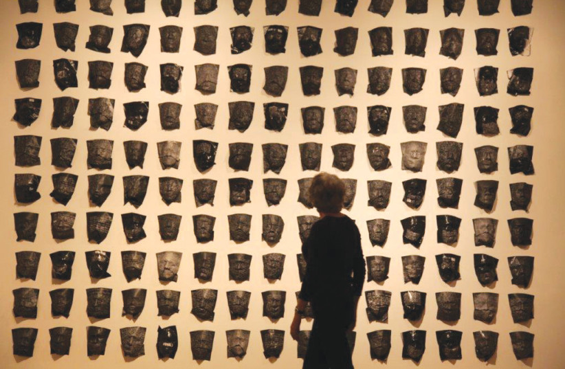  ‘Wall of Masks’ made of paper, reversed black and white photo copies of the original letters, now in Yad Vashem. Schreiber used her son and daughter as models for the molds of faces for her grandfather and grandmother. This grid exhibits 150 of the 200 masks she made. (photo credit: Courtesy)