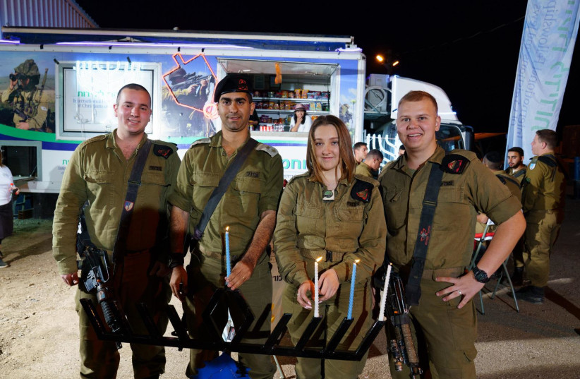  Soldiers from Sufa battallion light candles with IDCJ IDF Food Truck volunteers. (photo credit: Ancho-Josh-JINIPIX)