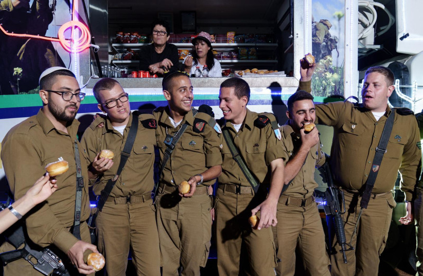   Soldiers from Sufa battallion light candles with IDCJ IDF Food Truck volunteers. (credit: Ancho-Josh-JINIPIX)