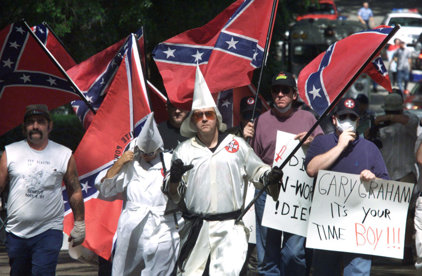  KU KLUX KLAN members approach Huntsville, Texas to protest an execution in 2000. The book’s protagonist was harassed by the Klan.  (photo credit: ADREES A. AAL/RCS/REUTERS)