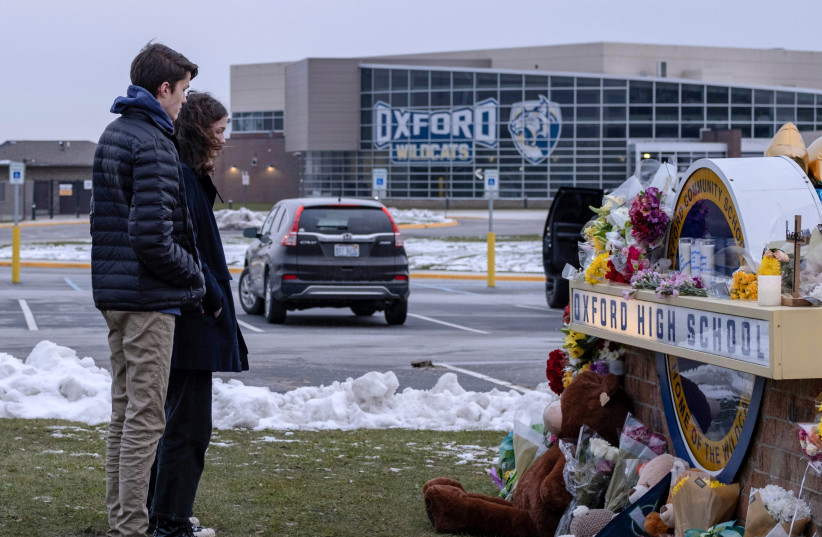 Students pay their respects at a memorial at Oxford High School a day after the year's deadliest U.S. school shooting which killed and injured several people, in Oxford, Michigan, US, December 1, 2021. (credit: REUTERS/SETH HERALD)