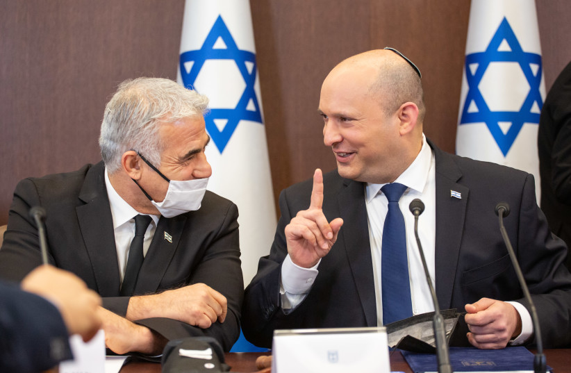  Prime Minister Naftali Bennett and Foreign Minister and alternate-prime minister Yair Lapid at the cabinet meeting, December 25, 2021. (photo credit: EMIL SALMAN/HAARETZ)