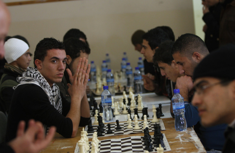 Palestinian university students take part in a chess competition at the Arab American University in the West Bank city of Jenin, December 13, 2010. (credit: REUTERS/ABED OMAR QUSINI)
