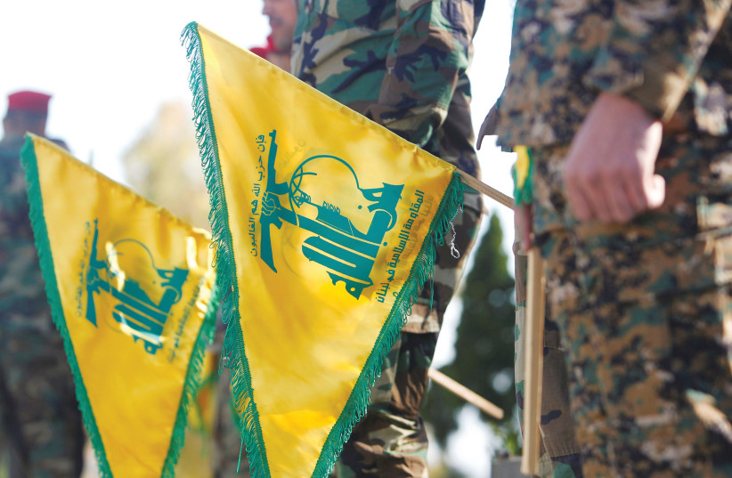  HEZBOLLAH MEMBERS hold flags marking Resistance and Liberation Day, in Kfar Kila near the Lebanese border with Israel in May. (credit: AZIZ TAHER/REUTERS)