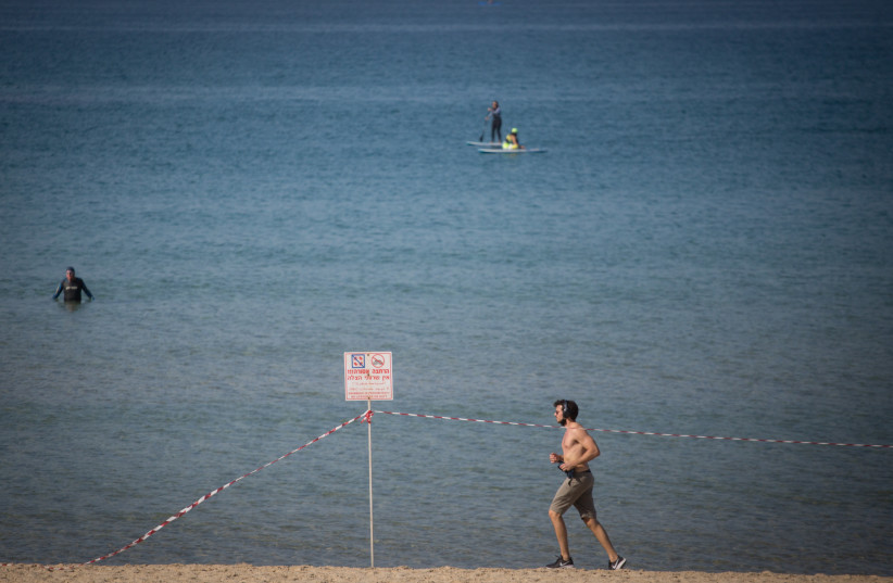 Israelis partake in recreational activities on the beach promenade in Tel Aviv during a nationwide lockdown, January 11, 2021. (credit: MIRIAM ALSTER/FLASH90)