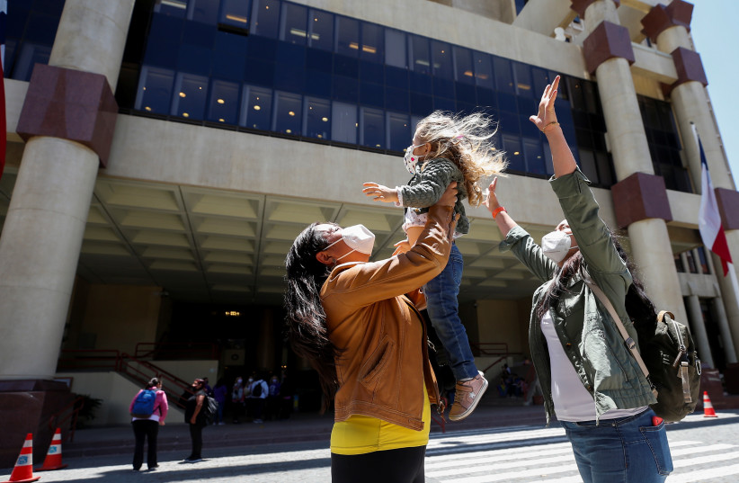  A couple reacts with their daughter outside the Congress as the Senate vote to approve a same-sex marriage bill in Valparaiso, Chile December 7, 2021. (credit: REUTERS/RODRIGO GARRIDO)