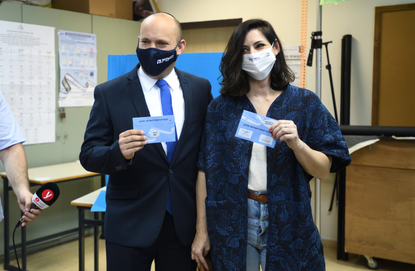  Prime Minister Naftali Bennett and wife Gilat case their ballots in the March election at a Ra'anana polling station (credit: GILI YAARI/FLASH90)