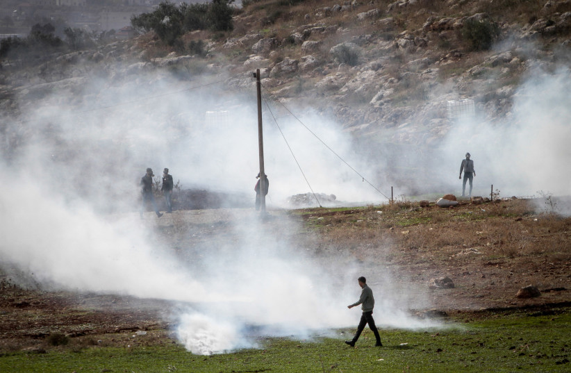  Palestinians clash with Israeli security forces during a protest in the village of Beit Dajan, near the West Bank city of Nablus on December 10, 2021.  (photo credit: NASSER ISHTAYEH/FLASH90)
