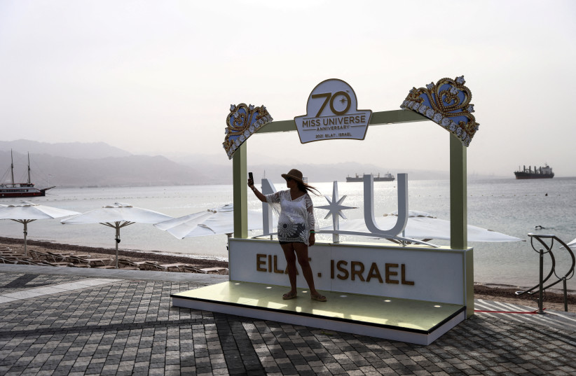  A woman takes a selfie in front of the Red Sea ahead of the annual beauty pageant Miss Universe which will take place later tonight in Eilat, Israel December 12, 2021. (credit: RONEN ZVULUN/REUTERS)