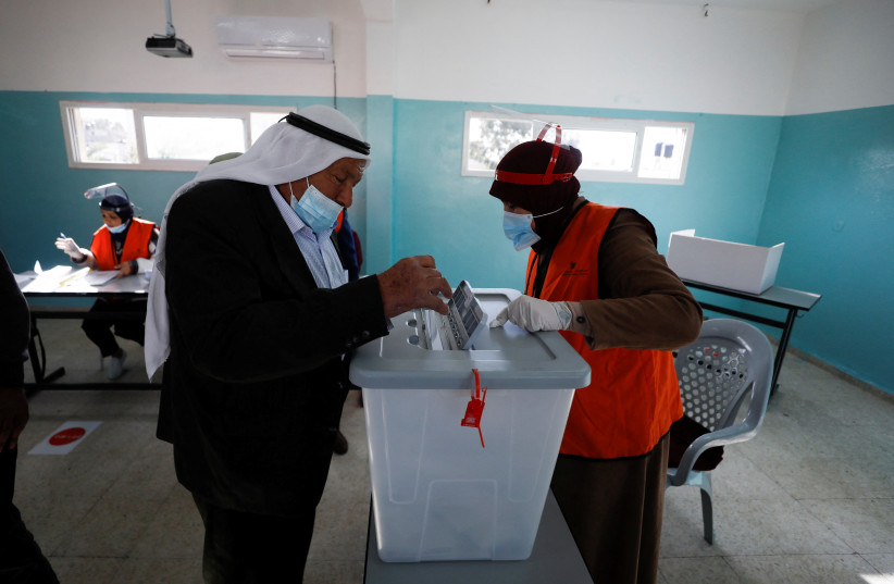 A Palestinian casts his ballot to vote in the municipal elections, near Jenin in the West Bank, December 11, 2021 (photo credit: REUTERS/MOHAMAD TOROKMAN)