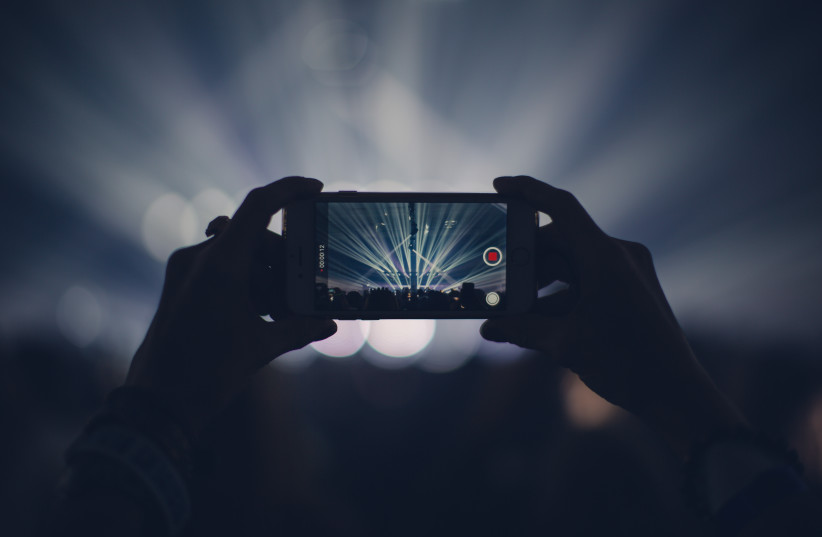  Capturing a video recording using a cell phone (Illustrative) (photo credit: UNSPLASH)