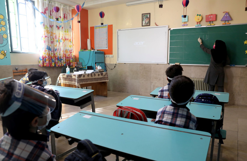  Students and their teacher wear protective gear to help prevent the spread of the coronavirus disease (COVID-19), in a classroom at Al-Mahdi School in Tehran (photo credit: MAJID ASGARIPOUR/WANA/REUTERS)