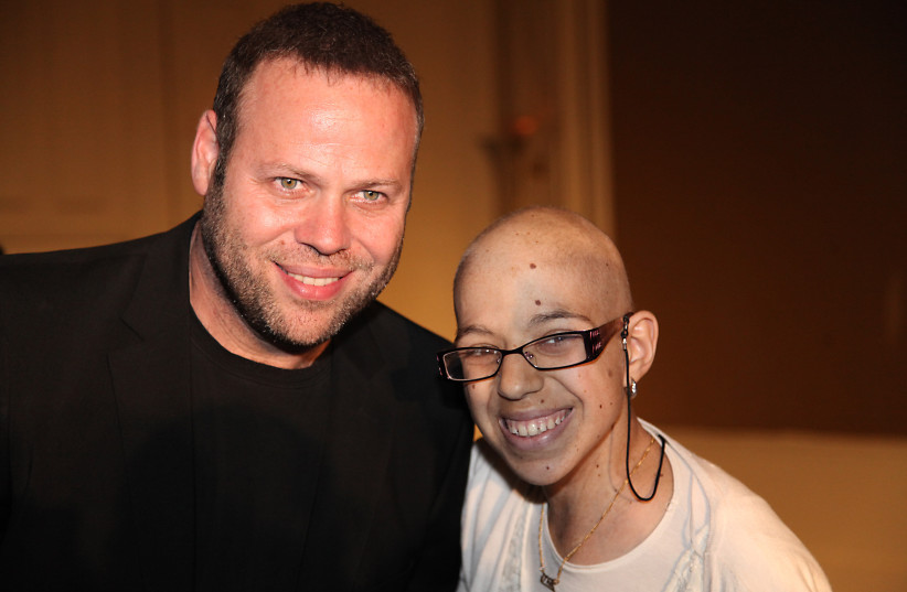 Adir Miller, Israeli actor, Screenwriter and comedian poses for a picture with a cancer patient during an event of ''Ezra LeMarpeh'' Association at the David Intercontinental hotel in Tel Aviv on November 24, 2013.  (credit: GIDEON MARKOWICZ)
