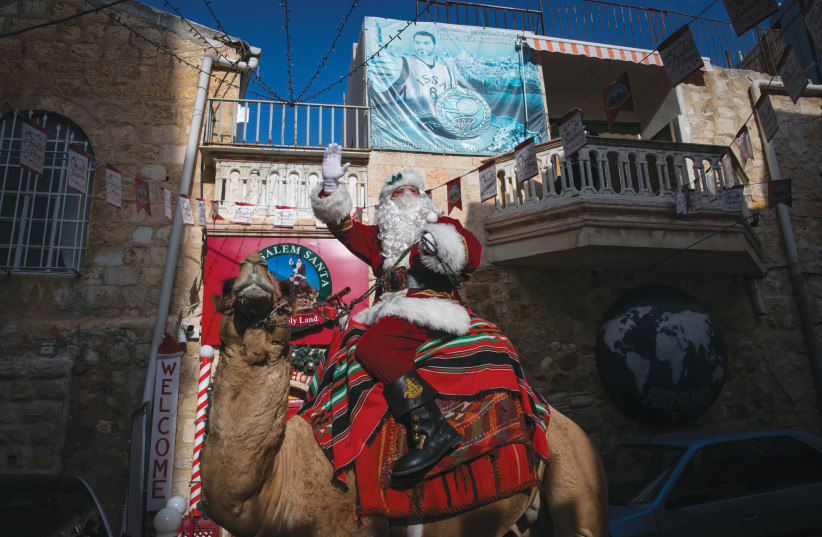  ISSA ANIS KASSISSIEH, aka Father Christmas, rides a festive camel at Jaffa Gate in Jerusalem’s Old City, December 2020.  (credit: OLIVIER FITOUSSI/FLASH90)