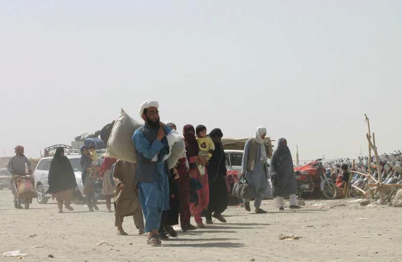 People from Afghanistan cross the 'Friendship Gate' in the Pakistan-Afghanistan border town of Chaman (credit: REUTERS)