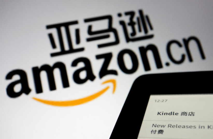 The sign of e-commerce website Amazon China is seen next to a Kindle e-reader displayed in this illustration, taken on December 15, 2021. (photo credit: REUTERS/FLORENCE LO/ILLUSTRATION)