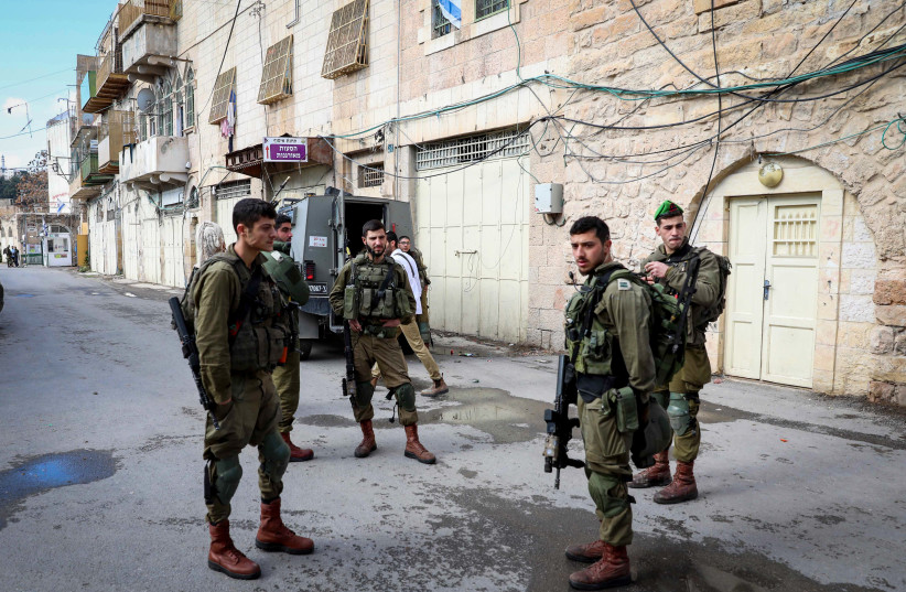  Israeli security forces at the scene of a stabbing attack, in the West Bank city of Hebron on December 18, 2021.  (photo credit: WISAM HASHLAMOUN/FLASH90)