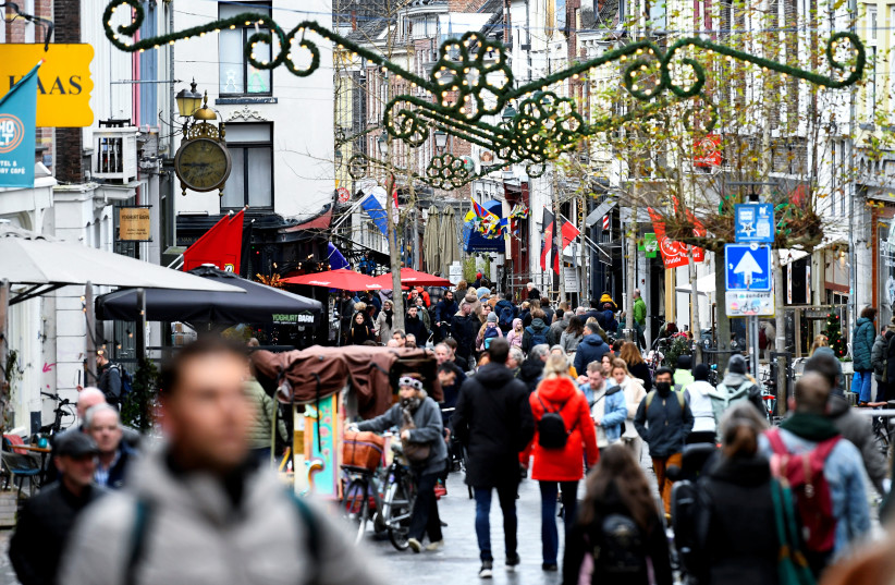 People do their Christmas shopping before the Dutch government's expected announcement of a "strict" Christmas lockdown to curb the spread of the Omicron coronavirus variant, in the city centre of Nijmegen, Netherlands, December 18, 2021. (photo credit: REUTERS/PIROSCHKA VAN DE WOUW)