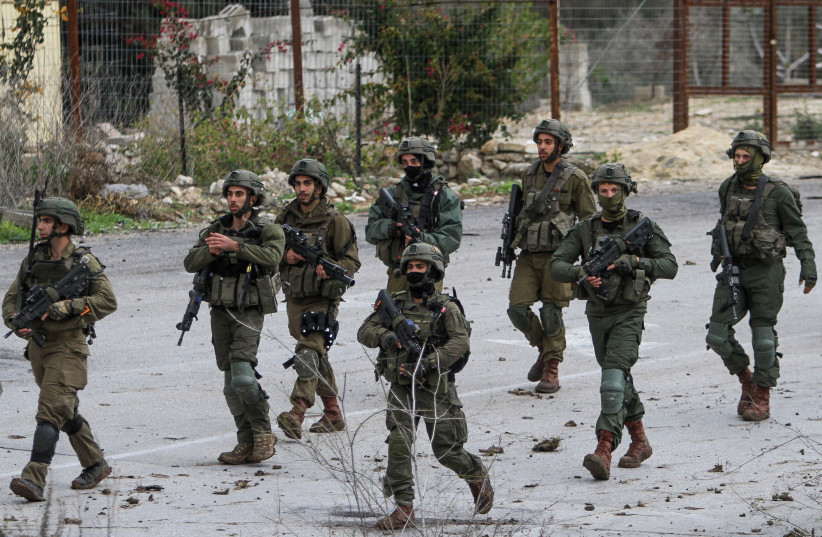  Israeli soldiers stand guard between Jewish settlers and Palestinians in the West Bank, on December 17, 2021. (photo credit: NASSER ISHTAYEH/FLASH90)