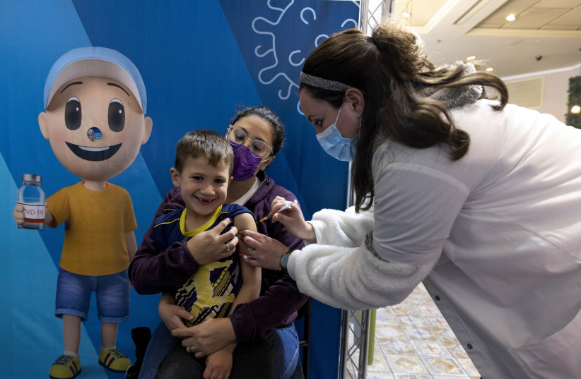  Children receive their dose of Covid-19 vaccine, at a Clallit vaccine center in Jerusalem on December16, 2021. (credit: OLIVIER FITOUSSI/FLASH90)