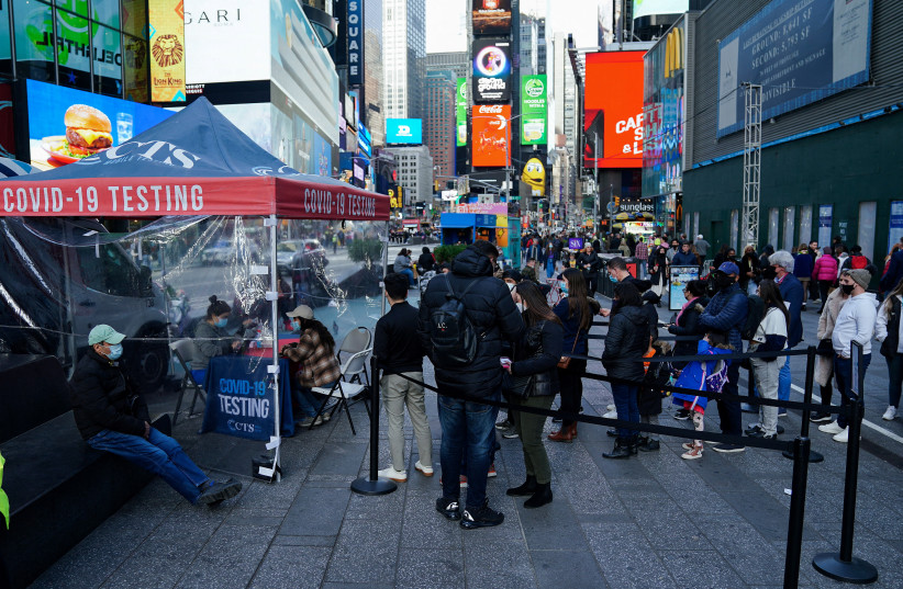  People line up at a COVID-19 testing site in Times Square during the coronavirus disease pandemic in the Manhattan borough of New York City, New York, US, December 17, 2021. (photo credit: REUTERS/CARLO ALLEGRI/FILE PHOTO)