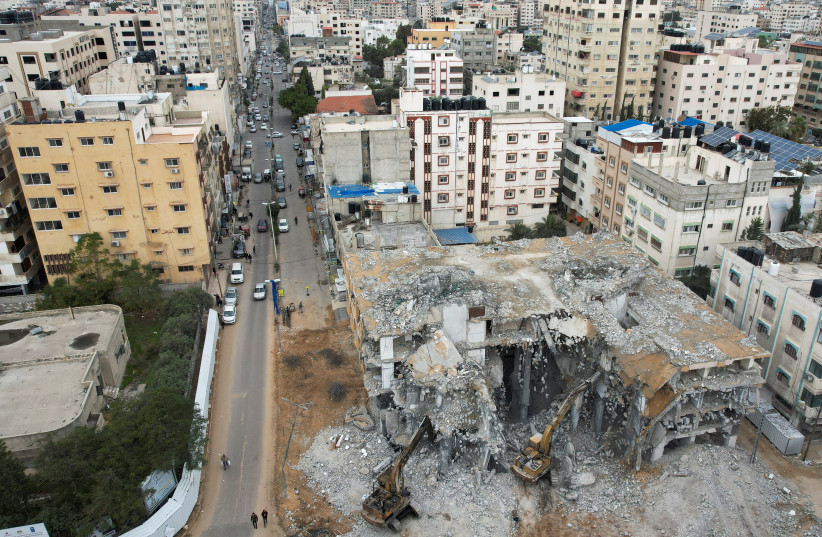  Bulldozers remove debris of Al-Jawharah Tower that was hit by Israeli air strikes during Israel-Palestine fighting last May, in Gaza City, December 21, 2021 (photo credit: MOHAMMED SALEM/REUTERS)