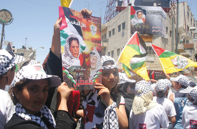 Palestinians in Ramallah hold posters showing Dalal Mugrabi, the leader of a Palestinian terror squad that hijacked an Israeli bus in 1978 and slaughtered 36 of its passengers, during a celebration marking her release from prison in 2008. (photo credit: ISSAM RIMAWI / FLASH 90)