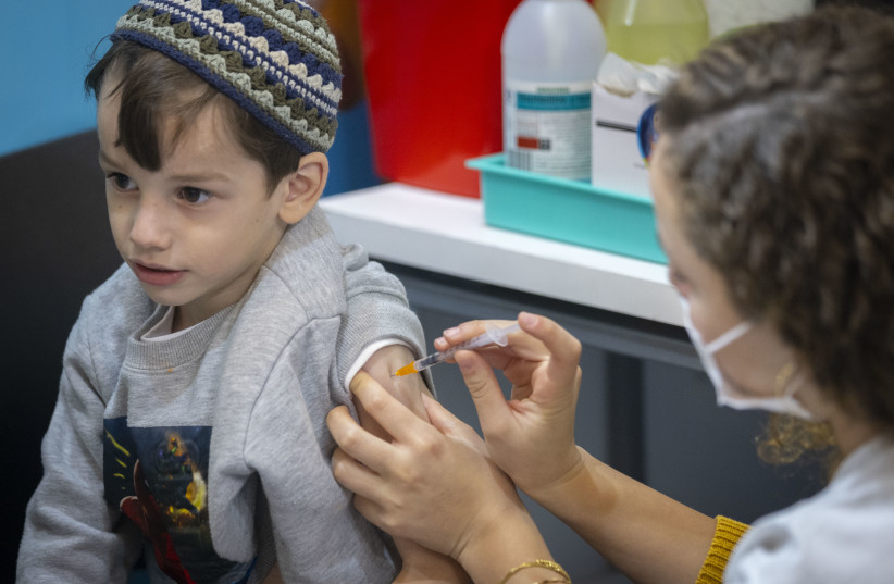  Children receive their dose of Covid-19 vaccine, at a Clallit vaccine center in Jerusalem on December 21, 2021.  (photo credit: OLIVIER FITOUSSI/FLASH90)