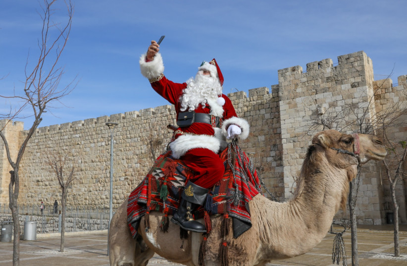  Issa Kassissieh, dressed as Santa Claus, rides a camel in Jerusalem's Old City (credit: MARC ISRAEL SELLEM)