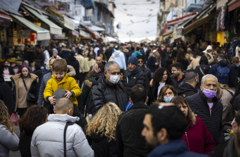  People some with facemasks shop at the Mahane Yehuda market in Jerusalem on December 24, 2021. (credit: OLIVIER FITOUSSI/FLASH90)