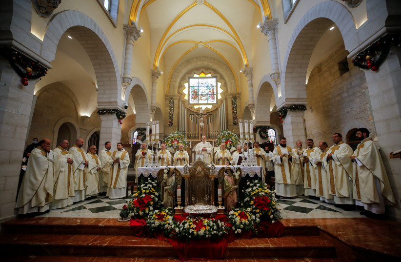  Worshippers attend Christmas morning mass as COVID-19 subdues festivities in Bethlehem (photo credit: REUTERS/MUSSA QAWASMA)