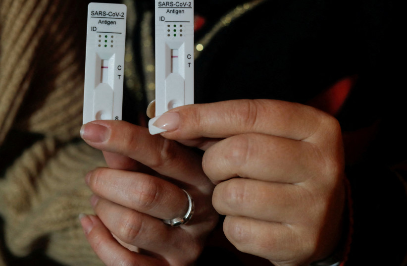  Women show their negative rapid test results after using COVID-19 self-test kits, in Malaga (photo credit: REUTERS/JON NAZCA)