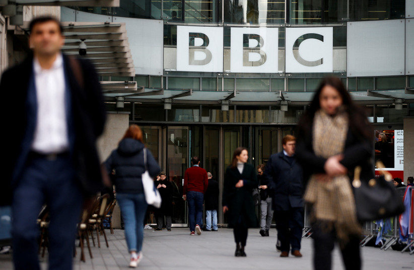 Pedestrians walk past a BBC logo at Broadcasting House in London, Britain, January 29, 2020. (credit: REUTERS/HENRY NICHOLLS/FILE PHOTO)