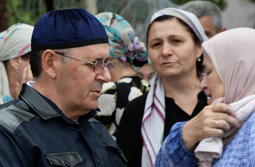 Oyub Titiev, the head of the Chechen office of the Memorial Human Rights Centre, talks with relatives after his release, outside of a penal colony settlement, in the town of Argun, in Chechnya, Russia, June 21, 2019. (credit: REUTERS/SAID TSARNAYEV)