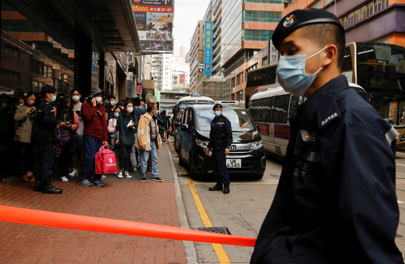 Police stand guard outside the Stand News office building, after six people were arrested ''for conspiracy to publish seditious publication'' according to Hong Kong's Police National Security Department, in Hong Kong, China, December 29, 2021. (credit: REUTERS/TYRONE SIU)