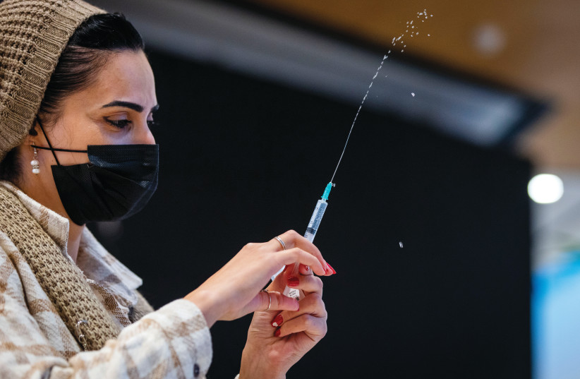  Prepping the vaccine at a Health Ministry center in Jerusalem's Malcha Mall (credit: OLIVIER FITOUSSI/FLASH90)