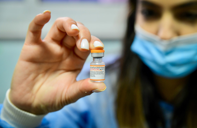  Proffering a vial of the Pfizer/BioNTech vaccine for children, at a Meuhedet vaccination center in Tel Aviv (credit: AVSHALOM SASSONI/FLASH90)