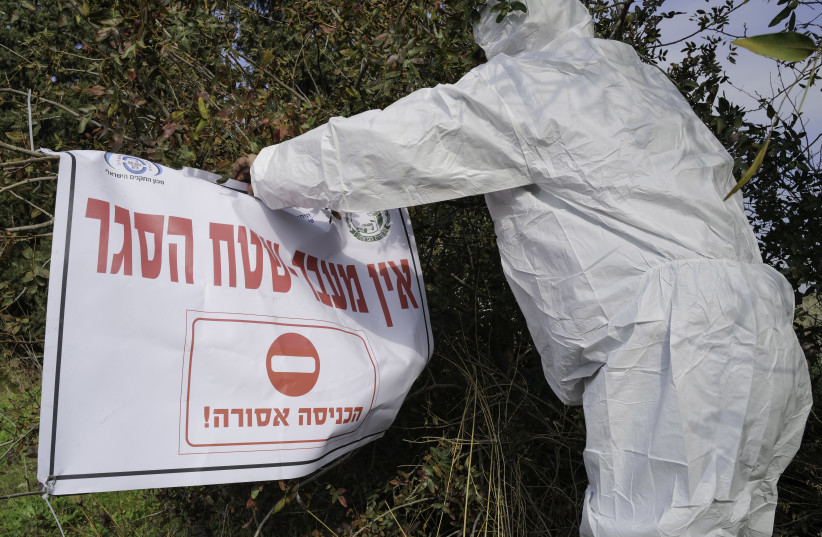  Workers in protective gear seen in Moshav Givat Yoav, in northern Israel, December 29, 2021, following an outbreak of avian influenza (photo credit: MICHAEL GILADI/FLASH90)