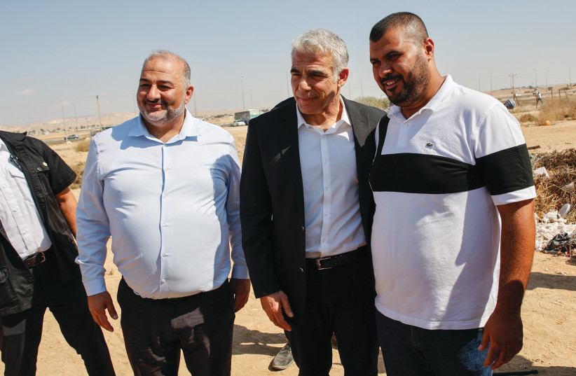  Ra'am leader Mansour Abbas and Foreign Minister Yair Lapid visit a high school in the Neve Midbar Regional Council, October 21 (credit: FLASH90)