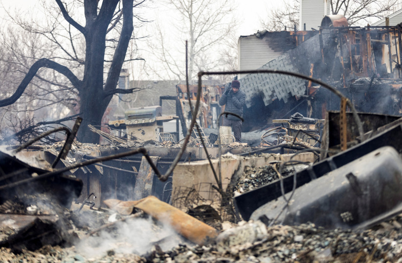  A man looks over the remains of his parents' home damaged by the Marshall Fire in Louisville, Colorado, U.S. December 31, 2021. (credit: REUTERS/ALYSON MCCLARAN)