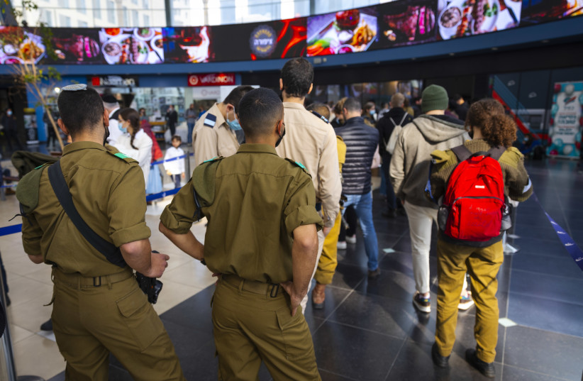  Israeli soldier line up in a queue at the entrance of a COVID-19 rapid antigen Magen David Adom testing center in Jerusalem on January 03, 2022. (credit: OLIVIER FITOUSSI/FLASH90)