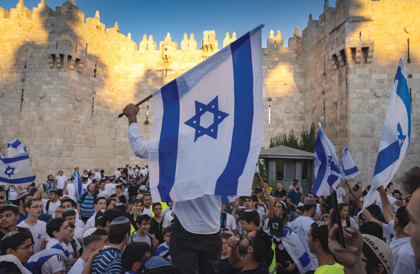  CELEBRANTS HOLD Israeli flags and dance during the March of Flags at the Damascus Gate in the Old City of Jerusalem in June. (photo credit: OLIVIER FITOUSSI/FLASH90)