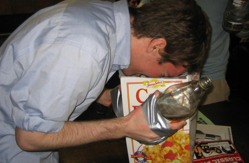  A man with a bottle of malt liquor affixed to his hand with duct tape, pictured in 2005. (photo credit: Andrew Ratto via WIKIMEDIA COMMONS)