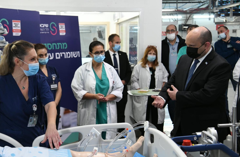  Prime Minister Naftali Bennett visiting Sheba Medical Center as COVID-19 Omicron cases soar in Israel, taken January 4, 2022 (credit: AMOS BEN-GERSHOM/GPO)