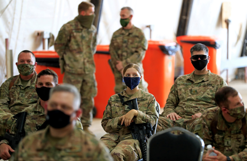 US soldiers wearing protective masks are seen during a handover ceremony of Taji military base from US-led coalition troops to Iraqi security forces, in the base north of Baghdad, Iraq August 23, 2020 (credit: REUTERS/THAIER AL-SUDANI)
