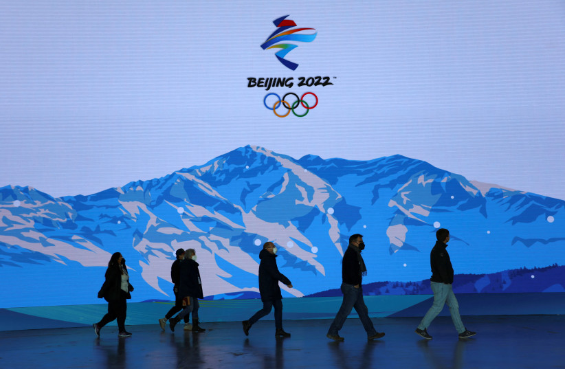  People are pictured at the Main Press Centre ahead of the Beijing 2022 Winter Olympics in Beijing (photo credit: REUTERS/FABRIZIO BENSCH)