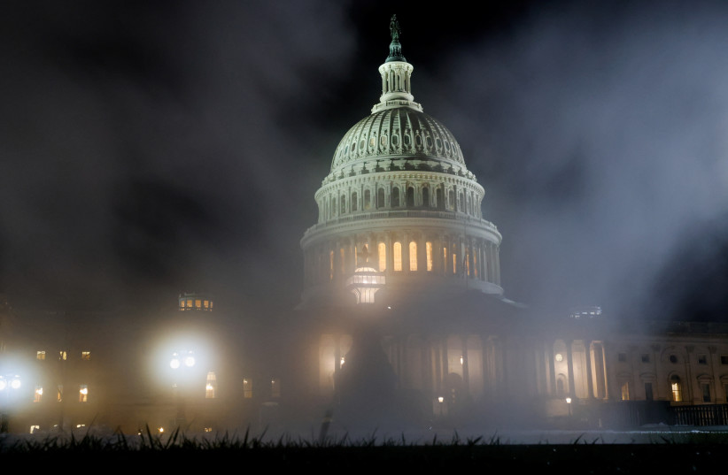  The US Capitol is seen through a steam exhaust on the first anniversary of the January 6, 2021 attack on the Capitol by supporters of former President Donald Trump, on Capitol Hill in Washington, US, January 6, 2022.  (photo credit: REUTERS/JONATHAN ERNST)